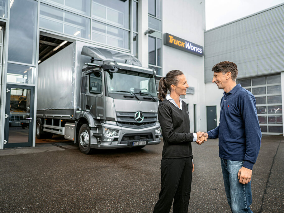 Mann und Frau stehen vor TruckWorks Werkstätte