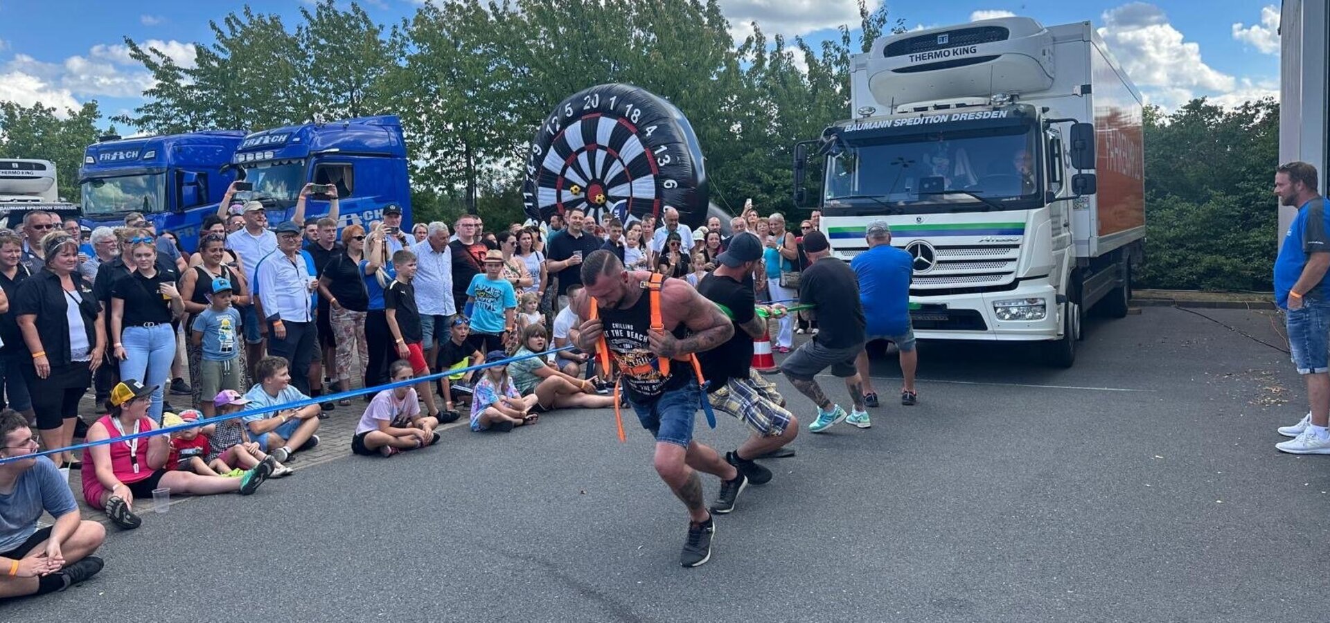 Männer ziehen einen Truck vor Publikum